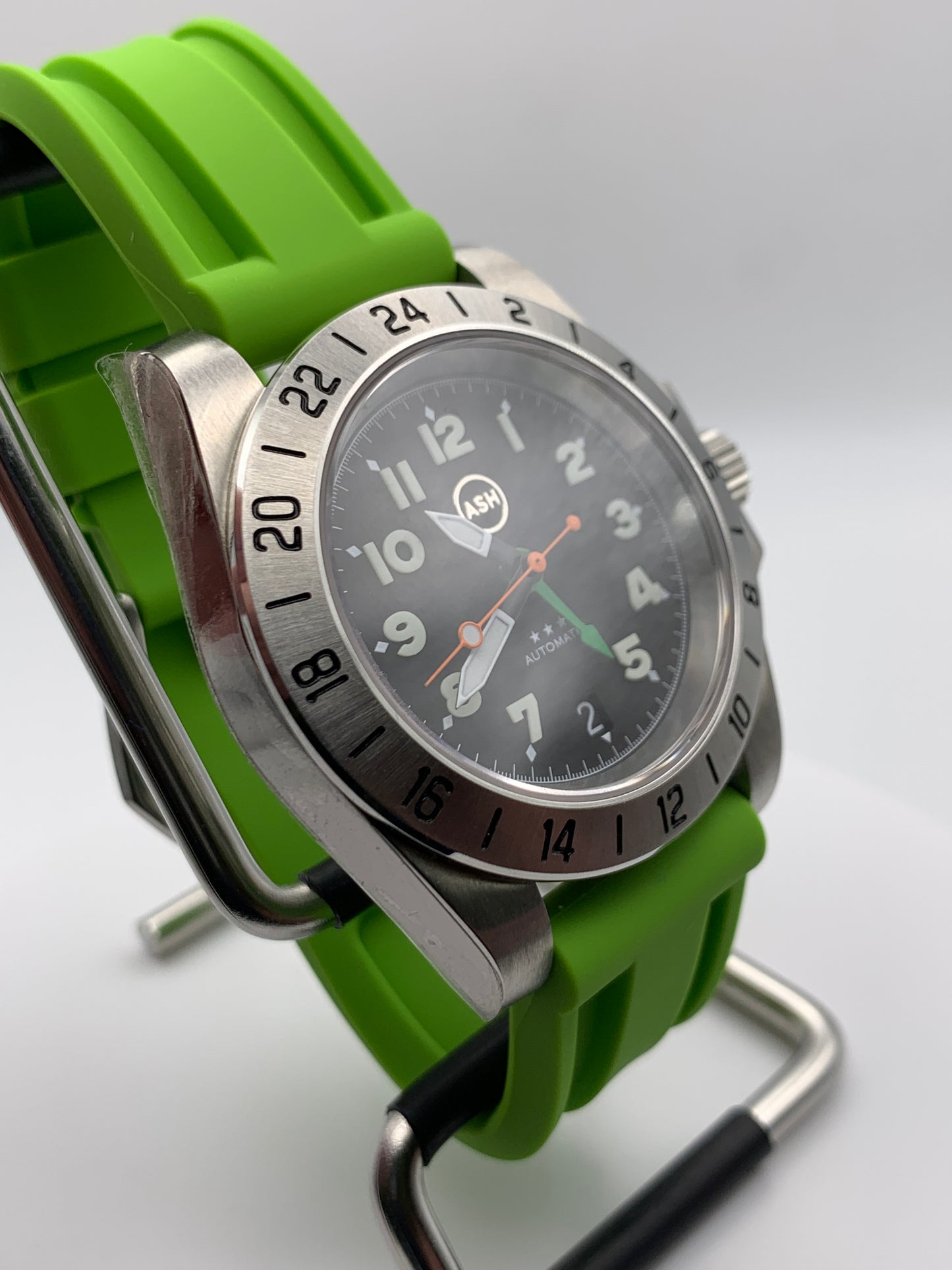 Gavin. 39mm Stainless steel GMT case. Sapphire crystal. 6 o’clock black date. Green and orange appointments. Seiko NH34.