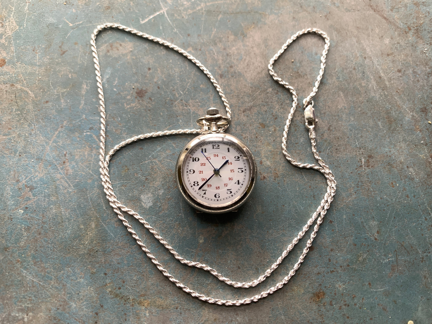 Amuse-bouche Deux. 30mm NOS Argentan alloy pocket / necklace watch. On a 24” 1.5mm sterling silver chain. Sapphire crystal. Vintage hand painted enamel dial. Miyota 2036.