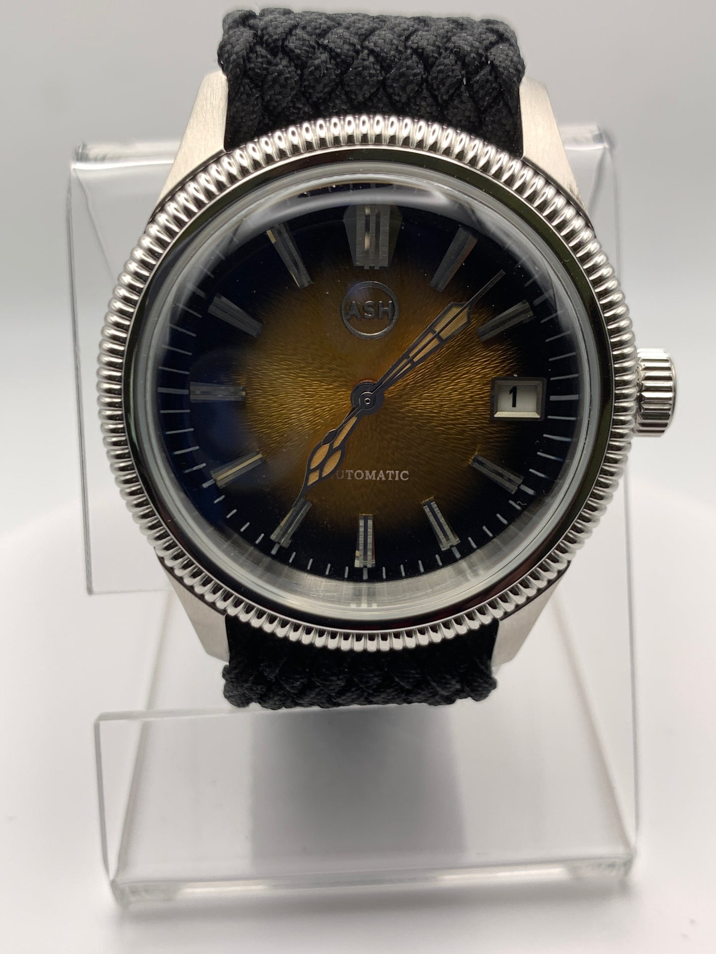 Homesick. 39mm Coin edged stainless steel case. Tobacco sunburst figured dial. AR coated domed mineral glass crystal. Seiko NH35 automatic movement.