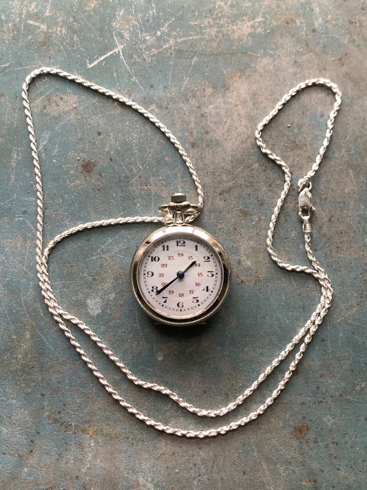 Amuse-bouche Deux. 30mm NOS Argentan alloy pocket / necklace watch. On a 24” 1.5mm sterling silver chain. Sapphire crystal. Vintage hand painted enamel dial. Miyota 2036.