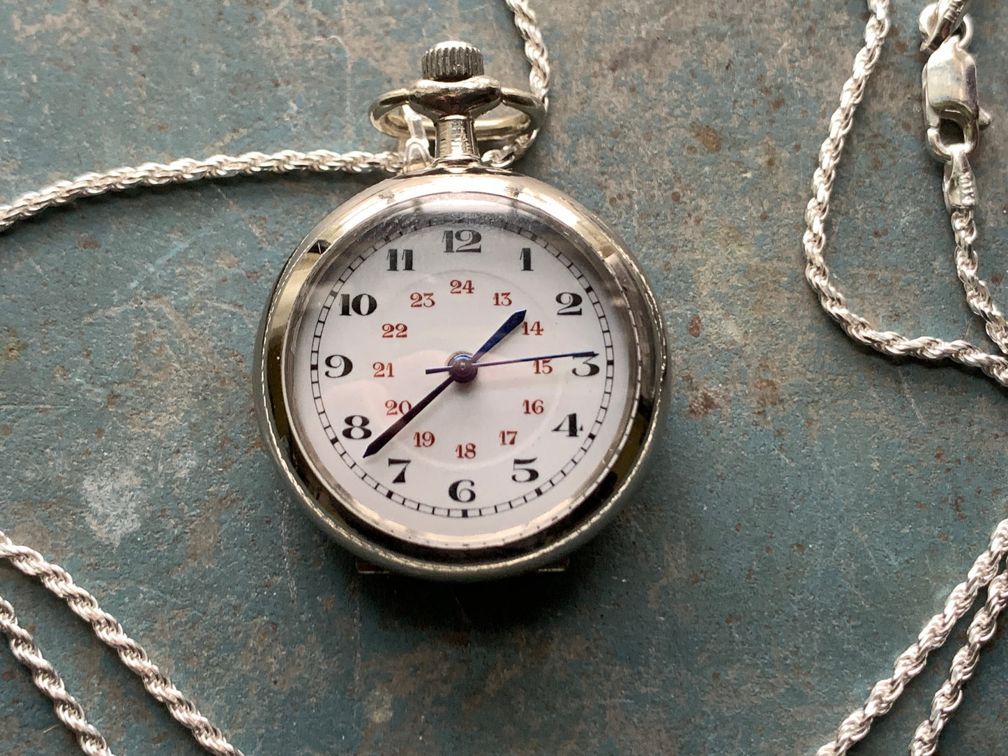 Amuse-bouche Deux. 30mm NOS Argentan alloy pocket / necklace watch. On a 24” 1.5mm sterling silver chain. Sapphire crystal. Vintage hand painted enamel dial. Miyota 2036.