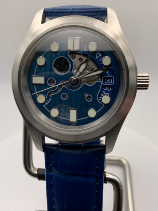 Wintermute. 39mm brushed stainless steel case. Domed sapphire crystal. Seiko NH35 with blue date wheel.
