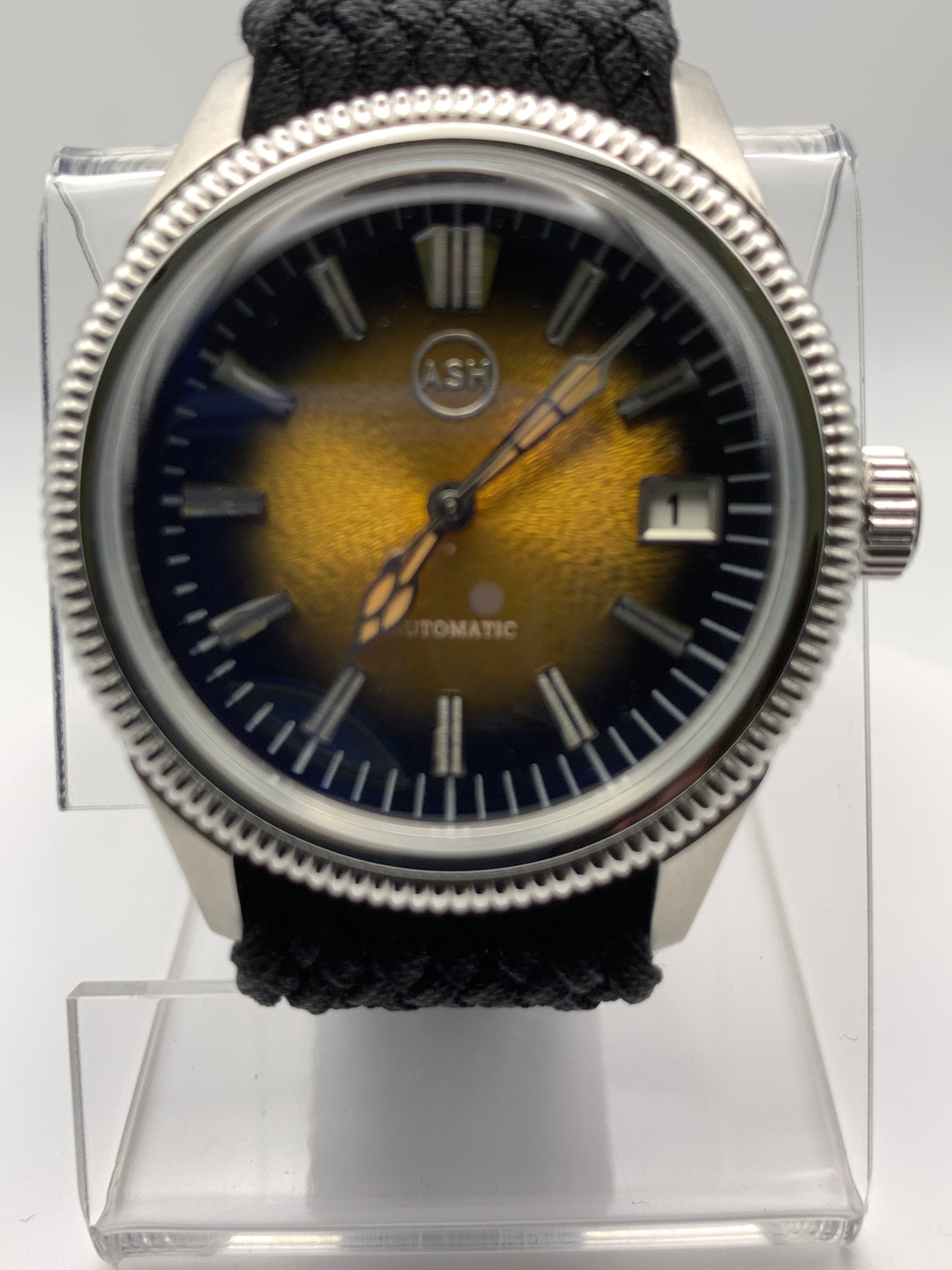 Homesick. 39mm Coin edged stainless steel case. Tobacco sunburst figured dial. AR coated domed mineral glass crystal. Seiko NH35 automatic movement.