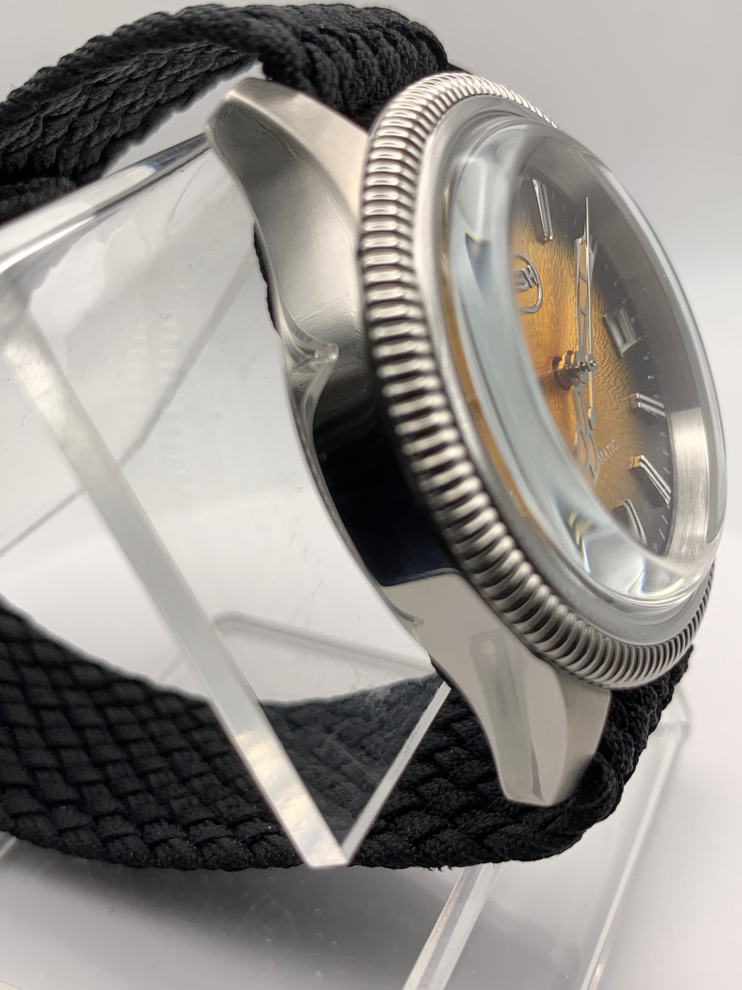 Homesick. 39mm Coin edged stainless steel case. Tobacco sunburst figured dial. AR coated domed mineral glass crystal. Seiko NH35 automatic movement.