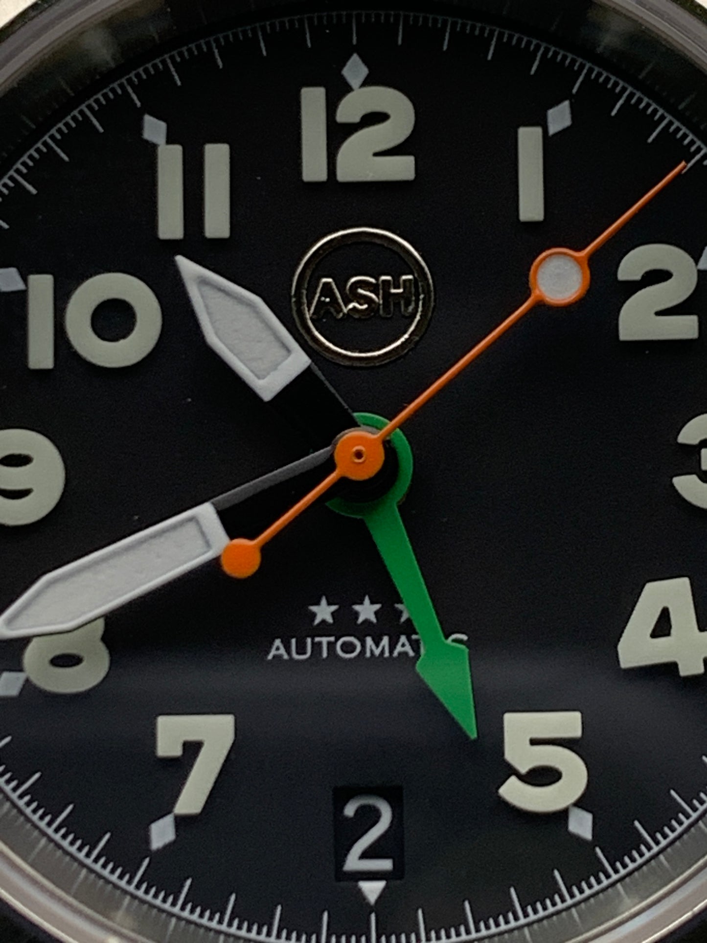 Gavin. 39mm Stainless steel GMT case. Sapphire crystal. 6 o’clock black date. Green and orange appointments. Seiko NH34.