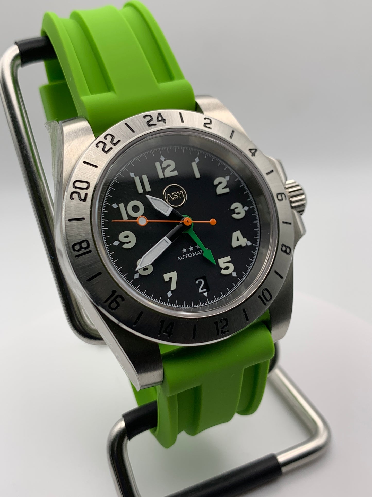Gavin. 39mm Stainless steel GMT case. Sapphire crystal. 6 o’clock black date. Green and orange appointments. Seiko NH34.