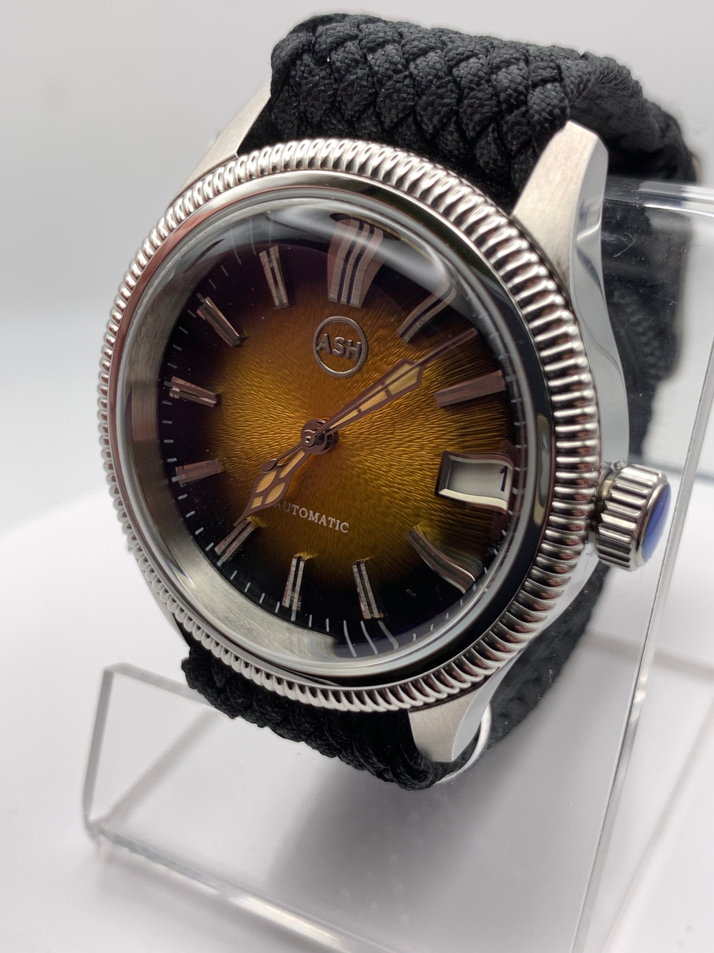 Homesick. 39mm Coin edged stainless steel case. Tobacco sunburst figured dial. AR coated domed mineral glass crystal. Seiko NH35 automatic movement.